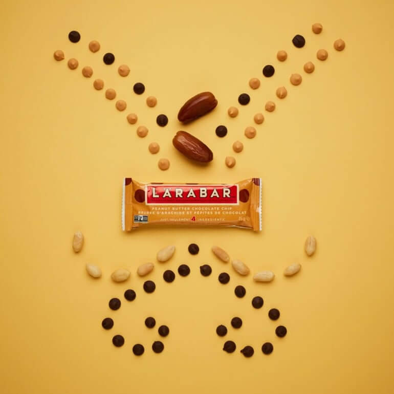Decorative image of a Peanut Butter Chocolate Chip Larabar with dates, peanuts, almonds and chocolate chips around it.