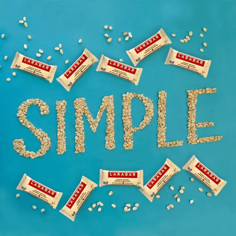 The word simple spelled out using ingredients with packs of Larabar around it.