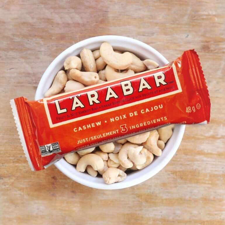 a red Larabar sitting in a cup of nuts