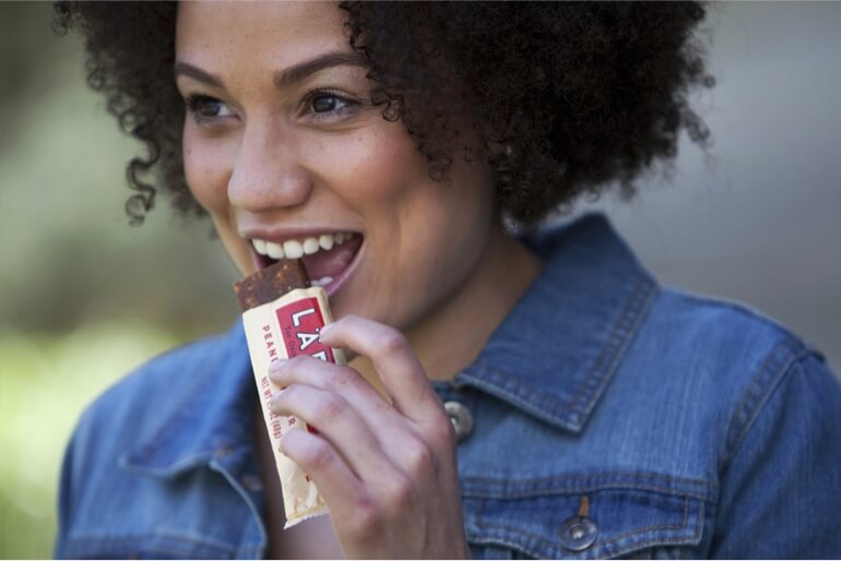 A woman eating a Larabar